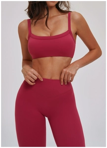 Dettaglio del set sportivo rosso lampone con reggiseno e leggings da yoga a vita alta