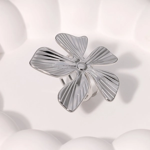 Vue macro d'une bague fleur en argent avec textures radiales sur cinq pétales métalliques