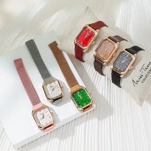 Detail of elegant rectangular quartz watches with metallic mesh bands and sunray dials