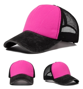 Detail of a pink and black trucker hat with breathable mesh and vintage washed denim brim