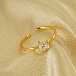 Détail d'une bague feuille d'érable dorée avec zircons marquise sur fond en soie chic