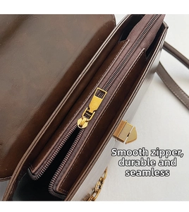 Detail view of the smooth golden metal zipper and interior compartments of the leather bag