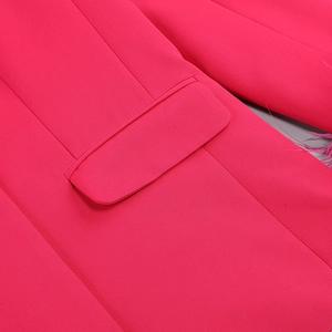 Detailed view of fuchsia blazer pocket with premium ostrich feather trim and fine stitching