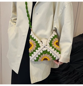Detail of hand-crocheted sunflower bag with green and yellow yarn textures and pearl buckle