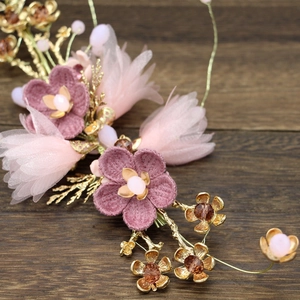 Detailed macro of handmade purple floral bridal headpiece with gold leaves and beads