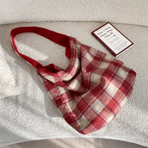 Detail of red and white plaid tote bag texture on a white sofa for daily use