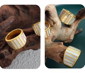 Detailed view of gold plated wide band ring featuring natural white shell inlay textures