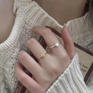 Detail of 925 silver starburst rings in gold and silver finish worn by a model