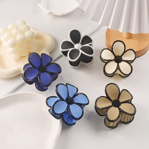 Five matte flower hair claws in navy, blue, white, and khaki on a soft aesthetic background