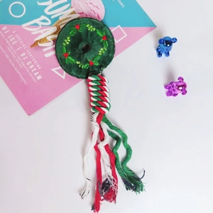 Detail view of durable Christmas themed pet rope toy with green plush ring and cotton knots