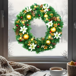 Christmas wreath detail with gold balls and pine cones against a cozy snowy window