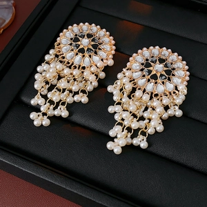 Detail of vintage heart pearl drop earrings with black and white gems on a jewelry tray