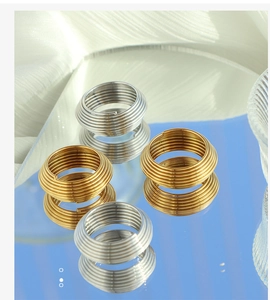 Macro view of multi-layer spiral striped rings in polished 18K gold and silver finish