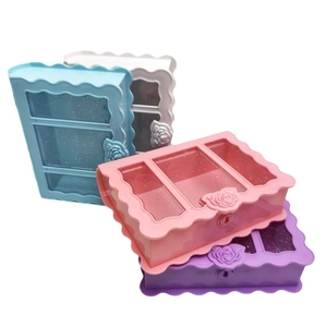 Mini book-shaped plastic jewelry boxes in pink, blue, white, and purple with glitter lids