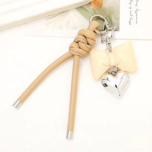 Close-up of khaki leather rope keychain with heart charm and bowknot detail