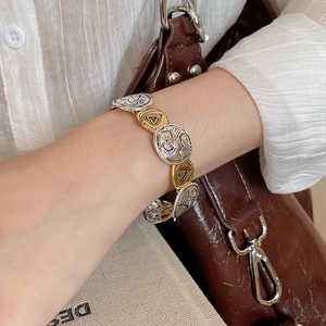Close-up of vintage metal bracelet with textured heart patterns and LOVE engravings