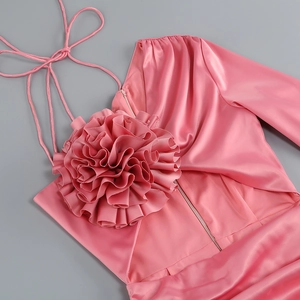 Détail de l'applique fleurie en satin 3D sur robe rose moulante sans manches