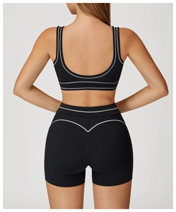 Back view of black yoga sports bra and high-waist shorts with white contrast stitching