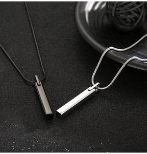 Detailed view of minimalist black and silver bar pendants on sleek snake chains