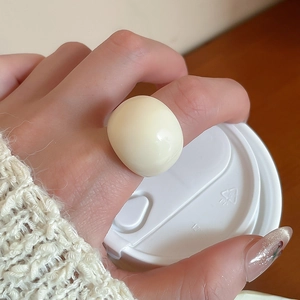 Macro shot of minimalist cream resin ring with a thick geometric circular design