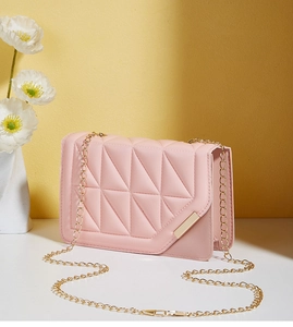 Detailed view of pink quilted shoulder bag featuring gold chain and triangle pattern texture