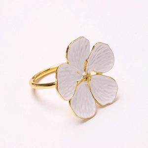 Elegant white enamel flower napkin ring with gold-plated edges and center on white base
