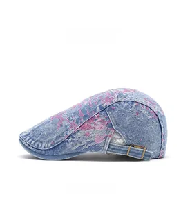 Dettaglio cappello denim con motivo invecchiato viola e fibbia metallica laterale
