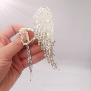 Detail of angel wing hair claw with cat eye stones and long rhinestone tassel chains