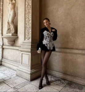 Détail d'une robe blazer noire avec dentelle blanche délicate et coupe ajustée élégante