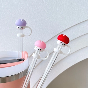 Close-up of silicone mushroom straw covers with cute smiling faces in purple pink and red