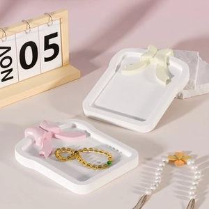Detailed view of toast-shaped jewelry trays with cute bow accents in cream and pink