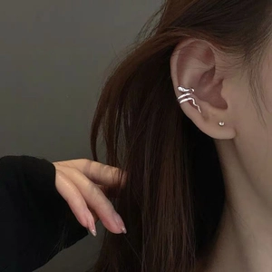 Silver snake ear cuff with a small round zircon stud earring set on model's ear