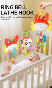 Détail de jouet en peluche coloré pour poussette avec crabe et singe sur le berceau