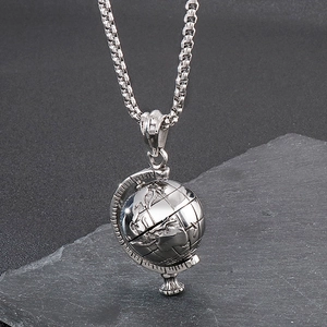 Detailed macro view of silver rotating globe pendant on textured stone background