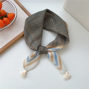 Detailed view of linen silk scarf with geometric patterns and white fringe tassels