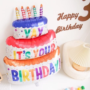 Detail of three-tier cake foil balloon with colorful candles for birthday party decor