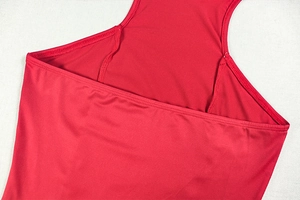 Detail view of bright red tiered dress showing precision stitching and knit fabric texture