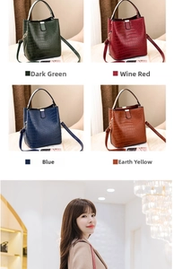 Detail view of four crocodile-patterned bucket bags in dark green, red, blue, and brown