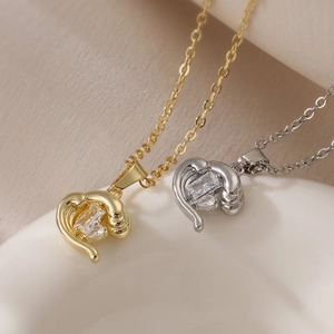 Elegant gold and silver irregular heart necklaces with zircon on white ceramic vessel