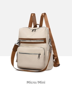 Detail view of cream white PU leather backpack featuring brown zippers and side hooks