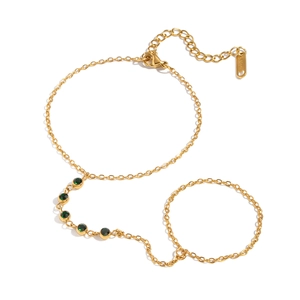 Gold stainless steel finger chain bracelet featuring a geometric green zircon gemstone
