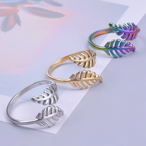 Detailed view of adjustable leaf rings in silver, gold, and rainbow stainless steel finishes