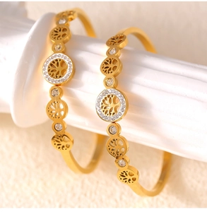 Detailed view of gold tree of life bangle featuring hollow design and white rhinestones