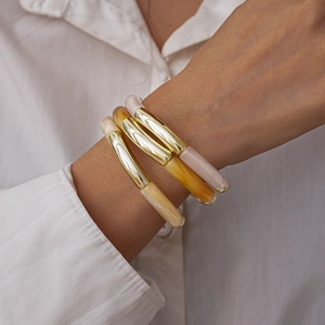 Close-up of three-piece stretch bracelets set in gold metal and marbled resin
