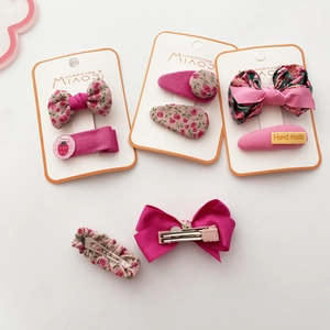 Detail of pink floral fabric bow hair clips and handmade accessories set for girls