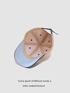 Detail of the six-panel interior stitching and metal buckle on this kids baseball cap
