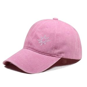 Detailed view of sun embroidery and washed pink fabric on this street style baseball cap