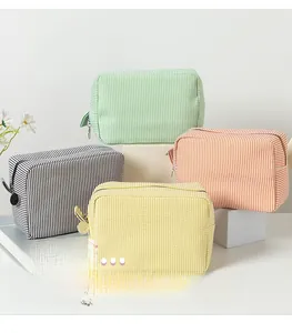 Detailed close-up of striped seersucker travel toiletry bags in four vibrant colors