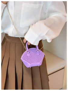 Detail of a purple woven mini bag with a top handle and elegant gold chain strap