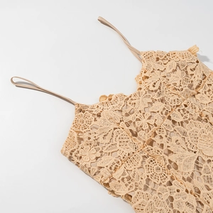 Macro detail of the beige crochet floral lace fabric and thin straps on the summer dress